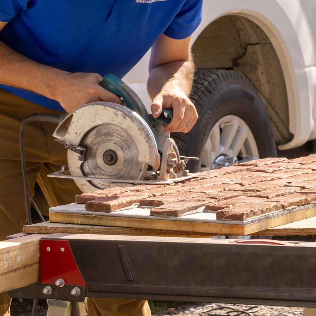 Worker sawing a thin brick panel